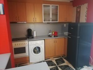 eine kleine Küche mit einem Kühlschrank und einer Waschmaschine in der Unterkunft Лукс апартамент in Stara Sagora