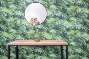 um espelho sobre uma mesa com um papel de parede verde em Residence Studio Vita em Bolonha