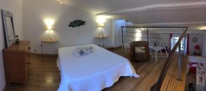 1 dormitorio con 1 cama blanca, mesa y sillas en Appartement rénové à 50 m de COLLIOURE Plage, Entrée autonome, Climatisé, en Collioure