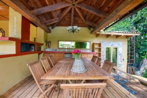 una mesa de madera con sillas y un jarrón de flores en una terraza en La Joya del Viento, en Valle de Bravo