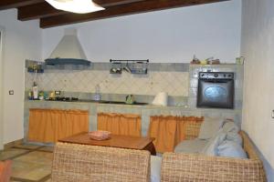 a kitchen with a table and a counter with a microwave at La Finestra Su Vigata in Porto Empedocle