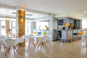 ein Zimmer mit Tischen und Stühlen sowie einer Küche in der Unterkunft Hotel Mimosa in Sidari