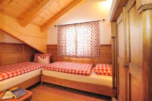 a room with two beds in a wooden cabin at Appartement Wolfenhof in Colle Isarco