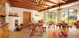 a kitchen with a table and chairs and a fireplace at Appartement Wolfenhof in Colle Isarco