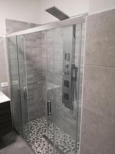 y baño con ducha y puerta de cristal. en MIRA B&B, en Campiano