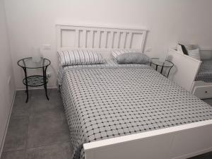 1 dormitorio con 1 cama blanca grande y 2 mesas en MIRA B&B, en Campiano