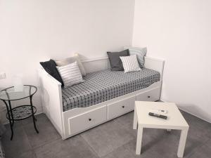 un sofá blanco con almohadas y una mesa en una habitación en MIRA B&B, en Campiano