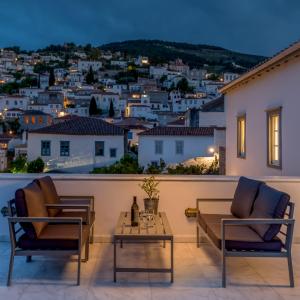 a patio with a view of a city at night at Hydras Chromata in Hydra