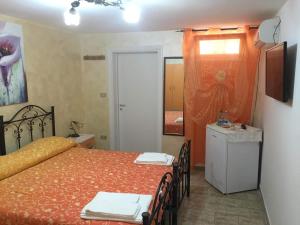 マリーナ・ディ・マンカヴェルサにあるBaccaversa camereのベッドルーム1室(ベッド1台、テーブル、椅子付)