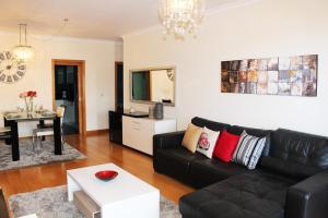 un soggiorno con divano nero e tavolo di MCStylo-Residenza a Funchal