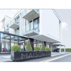 バルドリーノにあるMaisonMe Boutique Hotelの目の前に看板が立つ白い大きな建物