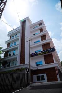 un edificio blanco alto con un letrero. en Ashoka Inn Chottanikkara en Chottanikara