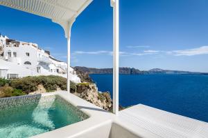 a view of the ocean from a house with a bathtub at Aris Caves in Oia
