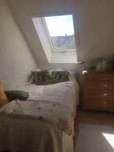 Habitación pequeña con cama y ventana en Jette’s værelsesudlejning en Rudkøbing