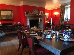 a dining room with a table and red walls at Marston Hall in Grantham