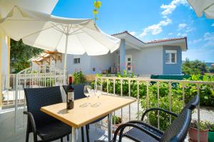 einen Tisch mit zwei Weingläsern und einem Regenschirm in der Unterkunft Studios Panagiota in Potos