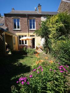 une maison avec un jardin fleuri devant elle dans l'établissement Gîte "La Maison", à Revin