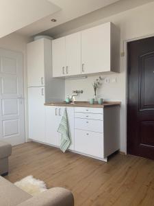 a kitchen with white cabinets and a wooden floor at Gem in Győr - free parking in Győr