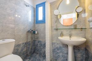 a bathroom with a sink and a toilet and a mirror at Kostantis Vacation Home 1 in Ambelas +17 photos