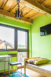 een slaapkamer met groene muren en een bed en een tafel bij Privát Simeon - ubytovanie v súkromí in Veľká Lomnica