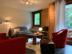 a living room with red chairs and a table at Residence le Paradis in Chamonix-Mont-Blanc