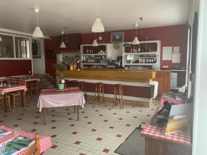 un restaurante con bar, mesas y sillas en Auberge du Mont Tortue, en Champclause
