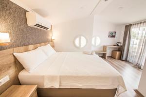 ein Schlafzimmer mit einem großen weißen Bett in einem Zimmer in der Unterkunft dekatria rooms&aparts in Kaş