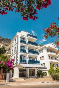 a white building with flowers in front of it at dekatria rooms&aparts in Kaş