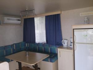 eine Küche mit einem Sofa, einem Tisch und einem Kühlschrank in der Unterkunft Camp Sita in Vir