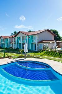 a villa with a swimming pool in front of a house at Residencial Mont Moria - Tonziro in Porto Seguro