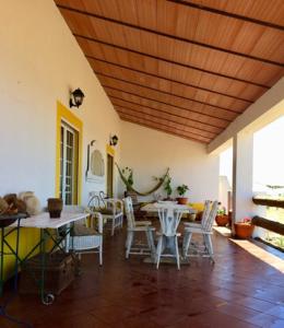uma sala de jantar com mesas e cadeiras e um tecto de madeira em Monte da Figueira em Amareleja