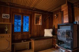 a living room with a stove and a window at Chalet Gasparjeva Velika Planina in Kamnik