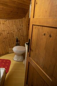 uma casa de banho com um WC e uma porta de madeira em Chalet Gasparjeva Velika Planina em Kamnik