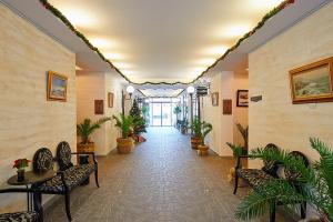 un couloir avec des chaises et des plantes en pot dans un bâtiment dans l'établissement Penelopa Palace Apart Hotel & SPA, à Pomorie