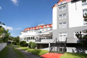 un grand bâtiment blanc avec des toits rouges dans l'établissement ACHAT Hotel Frankfurt Maintal, à Maintal