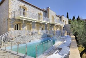 a building with a swimming pool next to a house at Manoleas Villas - Apartment 4 in Stoupa