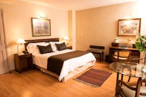 a hotel room with a bed and a table at Mayflower Suites in Buenos Aires