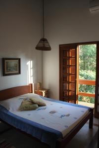 1 dormitorio con cama y ventana grande en Chaleilhabela, en Ilhabela