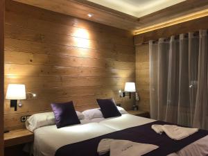 聖洛倫索德莫魯尼斯的住宿－皮特尤斯旅館，一间卧室设有两张床和木墙