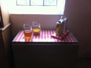 two glasses of orange juice and a box on a counter at Hanksville Farm in Svalöv