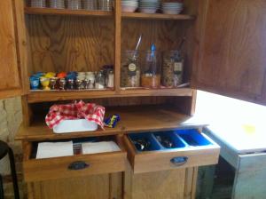 a kitchen with wooden cabinets and shelves with food at Hanksville Farm in Svalöv