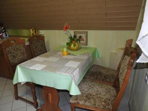 a dining room table with a green table and chairs at Private Ferienwohnung Fam.Wölke in Sondershausen