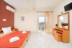 ein Schlafzimmer mit einem Bett und einem großen Fenster in der Unterkunft Studios Panagiota in Potos