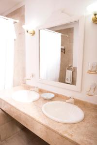 Mayflower Suites في بوينس آيرس: مغسلتين في حمام مع مرآة كبيرة