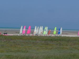 a row of sailboats on a beach with the ocean at LE BOUT DE LA VILLE in Hirel +13 photos