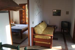 a living room with a couch and a television at Chaleilhabela in Ilhabela