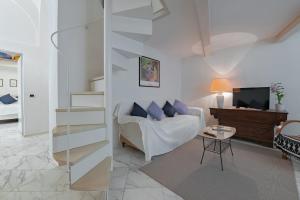 uma sala de estar com um sofá branco e uma mesa em Peruzzi Apartment em Florença
