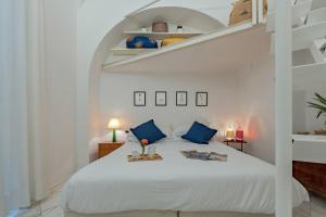 Dormitorio blanco con cama blanca y almohadas azules en Peruzzi Apartment, en Florencia