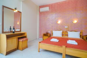 ein Schlafzimmer mit einem Bett mit Spiegel und Waschbecken in der Unterkunft Studios Panagiota in Potos