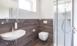 ein Bad mit einem WC, einem Waschbecken und einer Dusche in der Unterkunft Hotel Restaurant Zum Wacholderhain in Haselünne